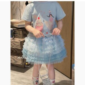 Girl wearing cupcake print tee with blue tulle skirt set
