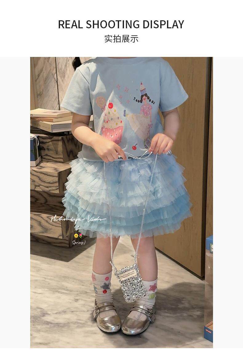 Girl wearing cupcake print tee with blue tulle skirt set